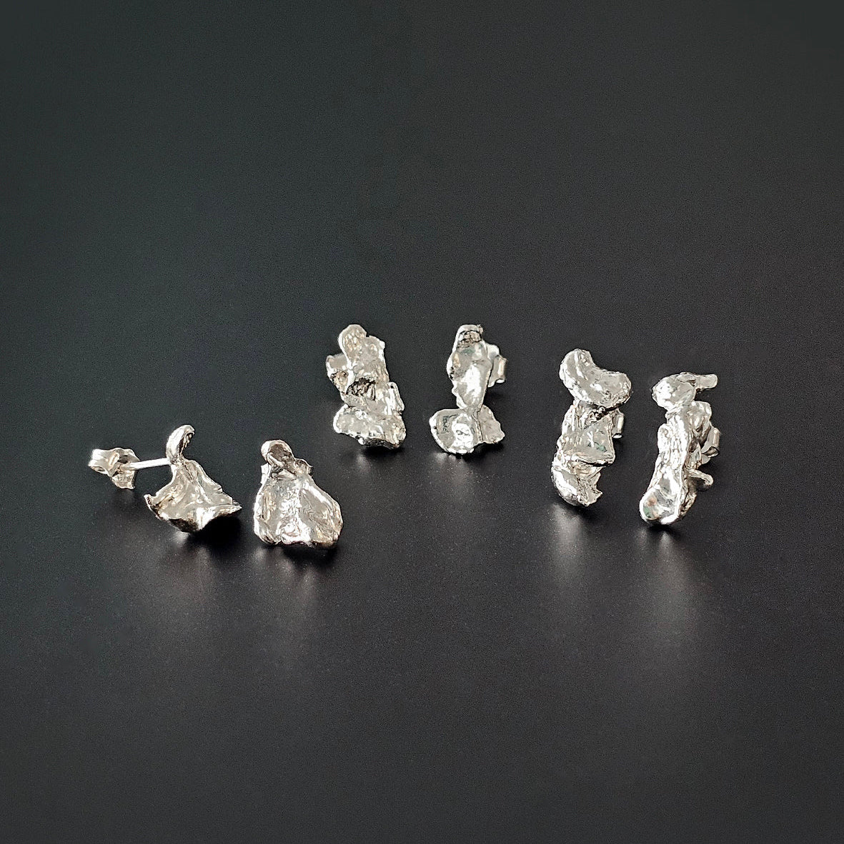 Set of silver earrings on a black background